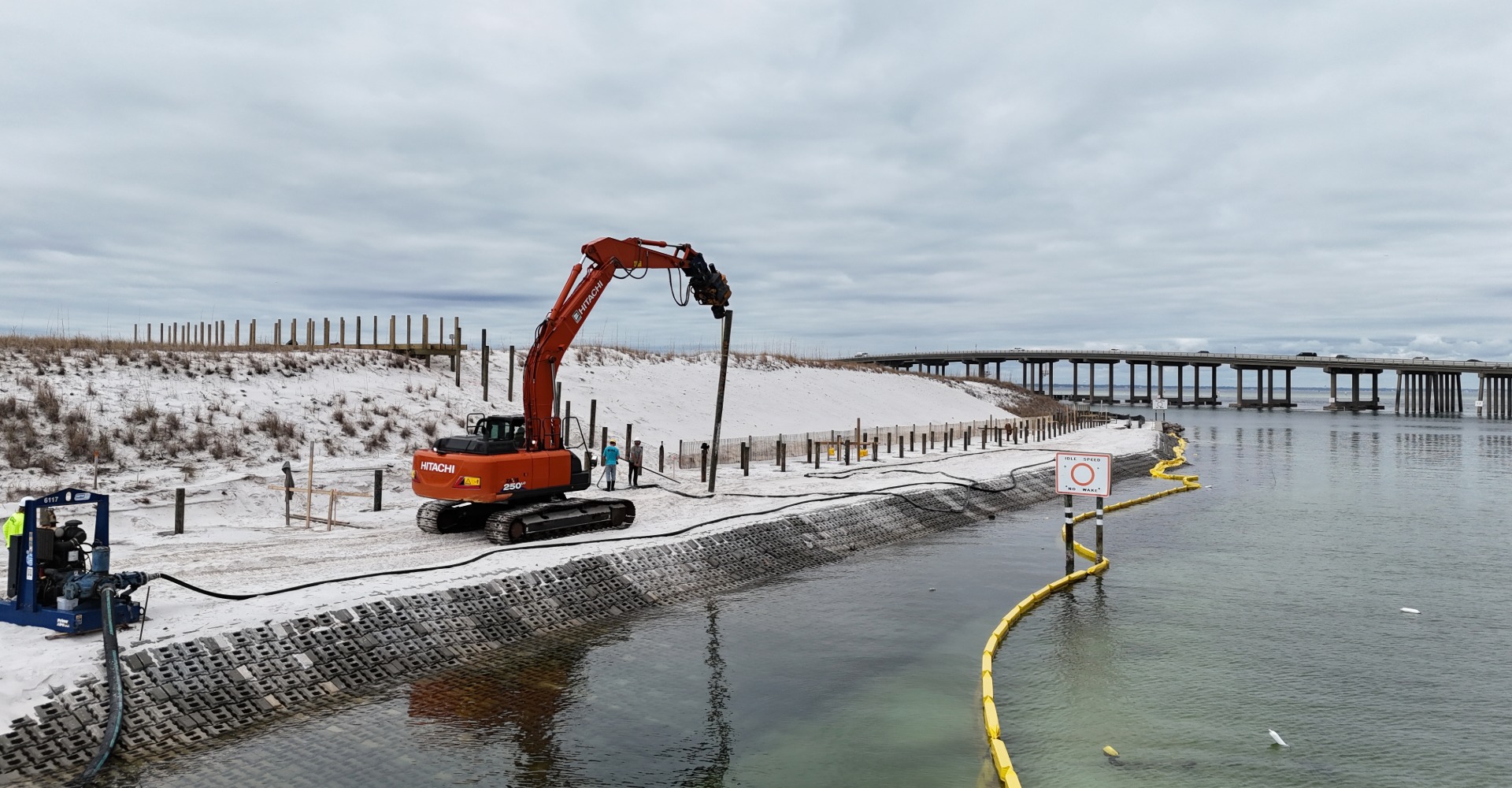 Excavator with drill on beach